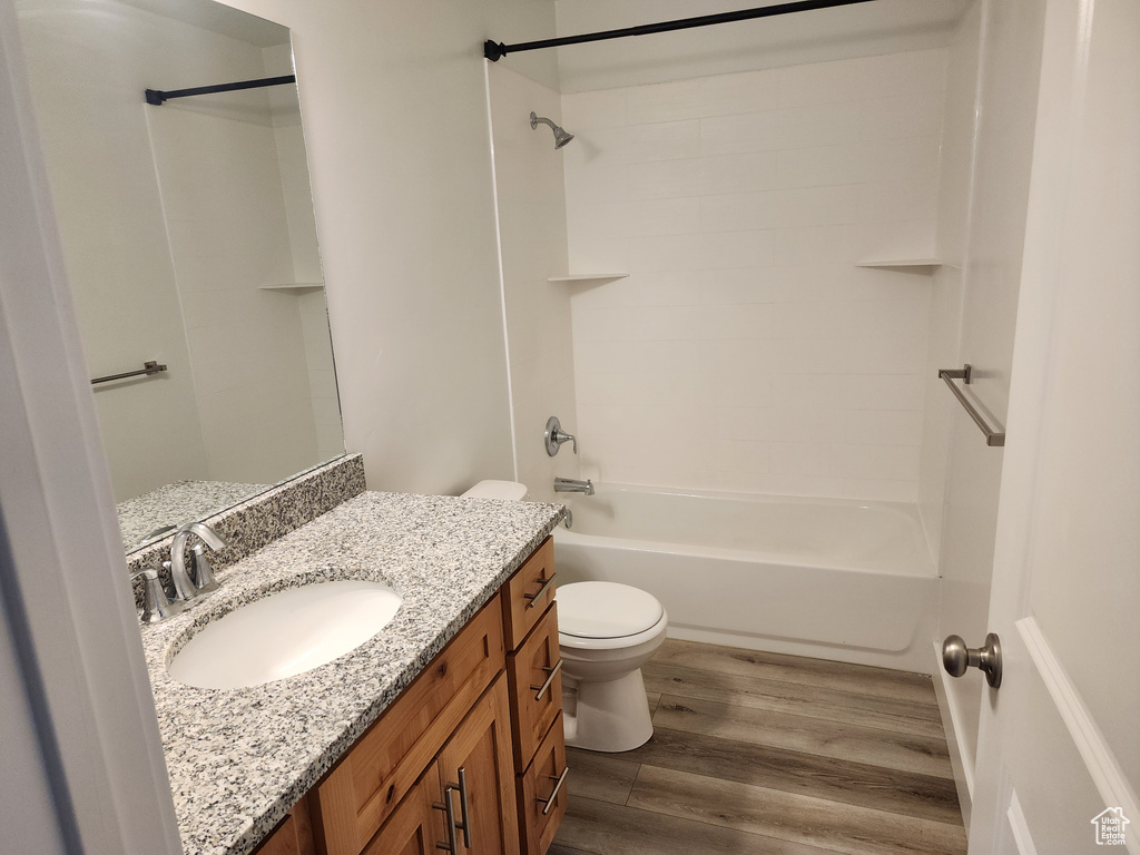 Bathroom featuring vanity, wood finished floors, and tub / shower combination