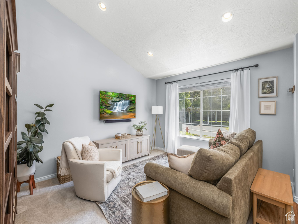 Living area with recessed lighting, lofted ceiling, and light colored carpet