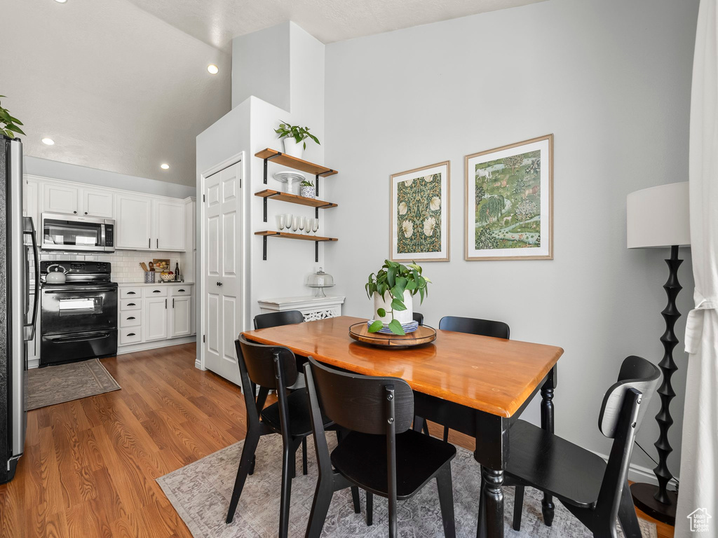 Dining space with light wood-style floors, recessed lighting, and lofted ceiling