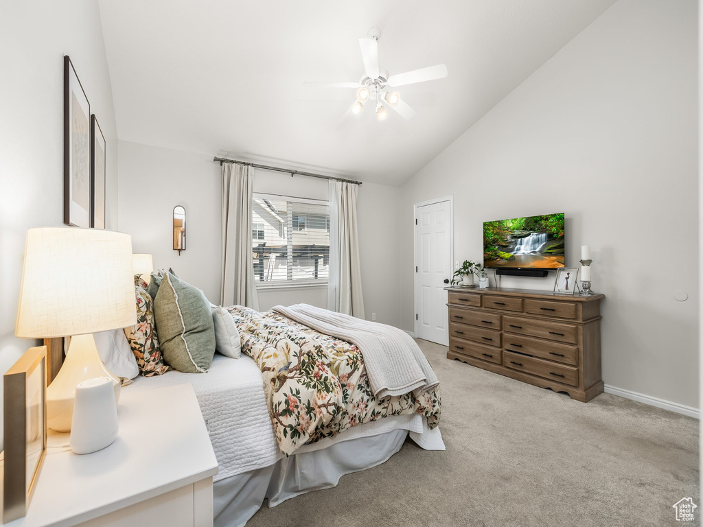Bedroom with lofted ceiling, light colored carpet, and ceiling fan