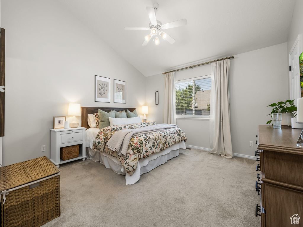 Bedroom featuring light carpet, lofted ceiling, and a ceiling fan