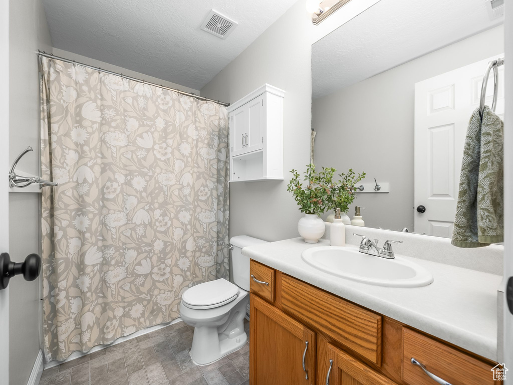 Full bath with vanity, stone finish floors, and a shower with curtain