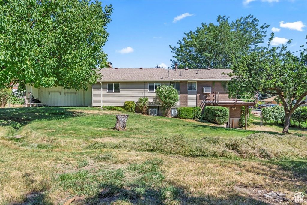 Rear view of property with a yard