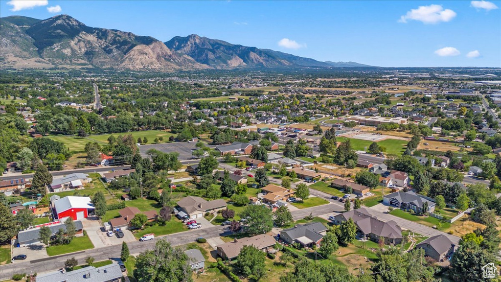 Aerial overview of property's location with a mountainous background and nearby suburban area