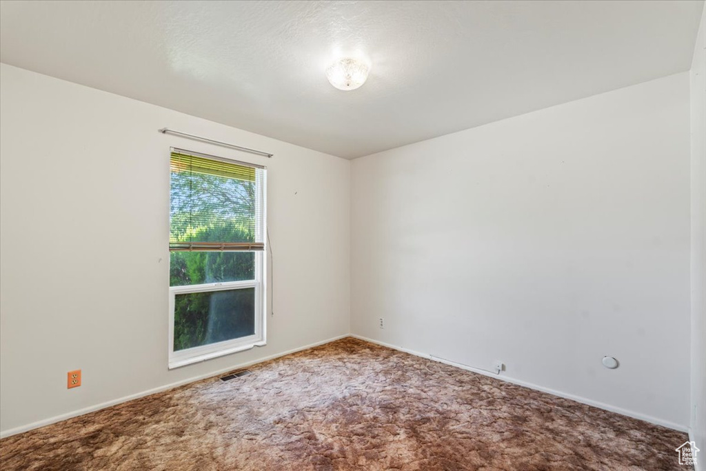 Carpeted spare room with baseboards