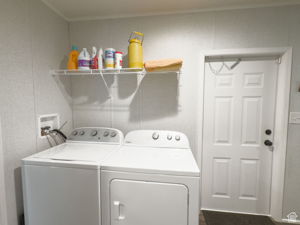 Washroom featuring washing machine and dryer and ornamental molding
