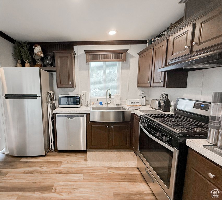 Kitchen featuring appliances with stainless steel finishes, light countertops, dark brown cabinets, and recessed lighting