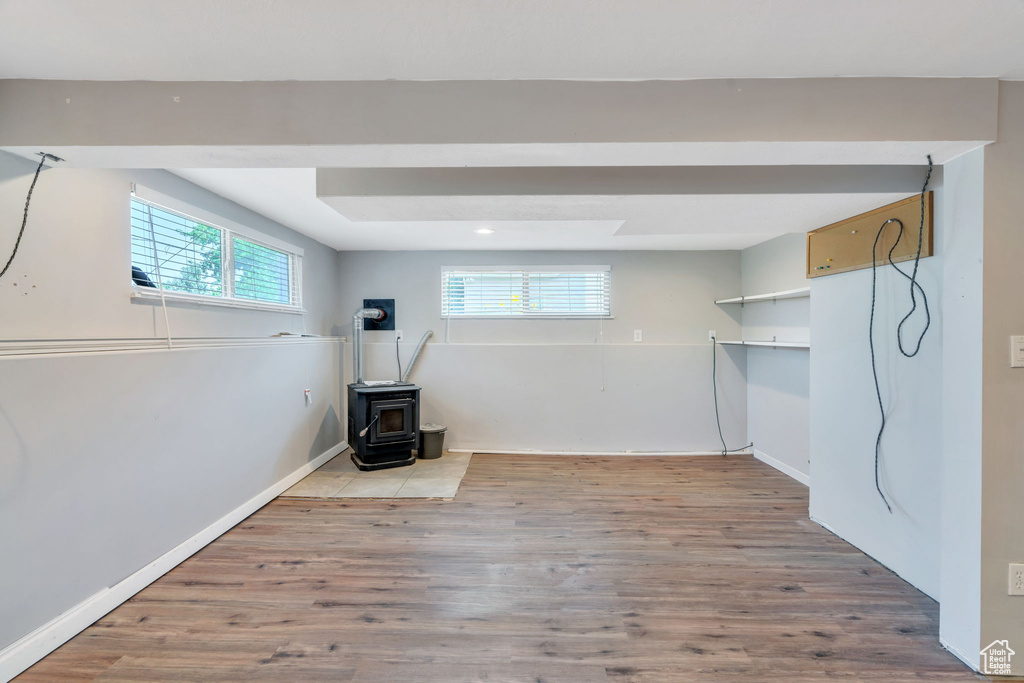 Below grade area with a wood stove, wood finished floors, and recessed lighting