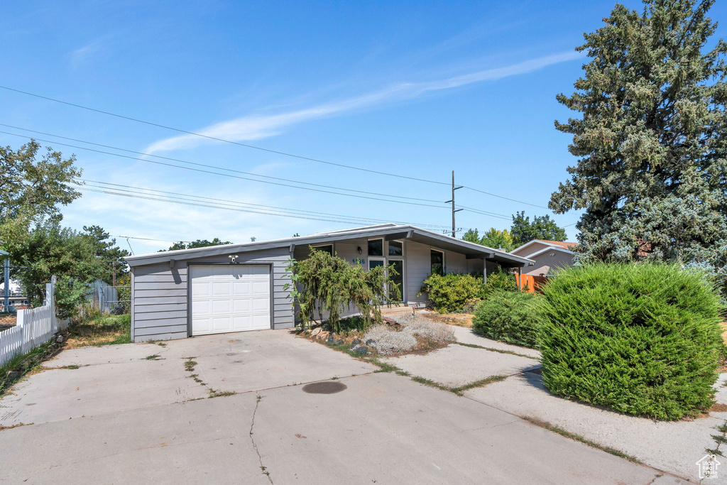 Mid-century modern home with concrete driveway and an attached garage