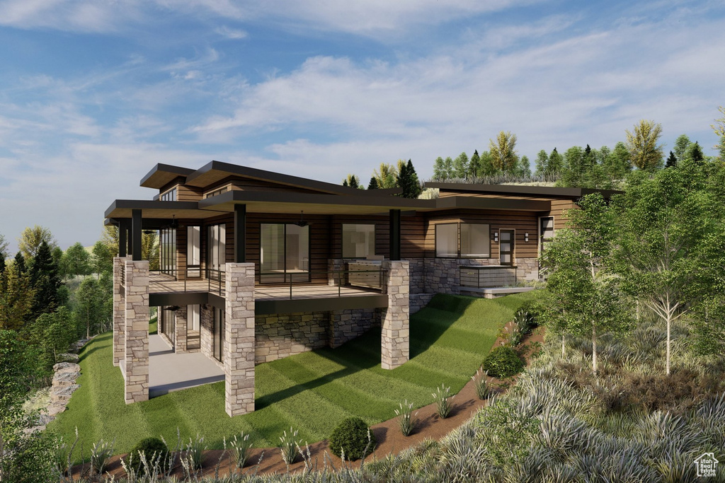 Back of property featuring stone siding, a balcony, a patio area, and a lawn