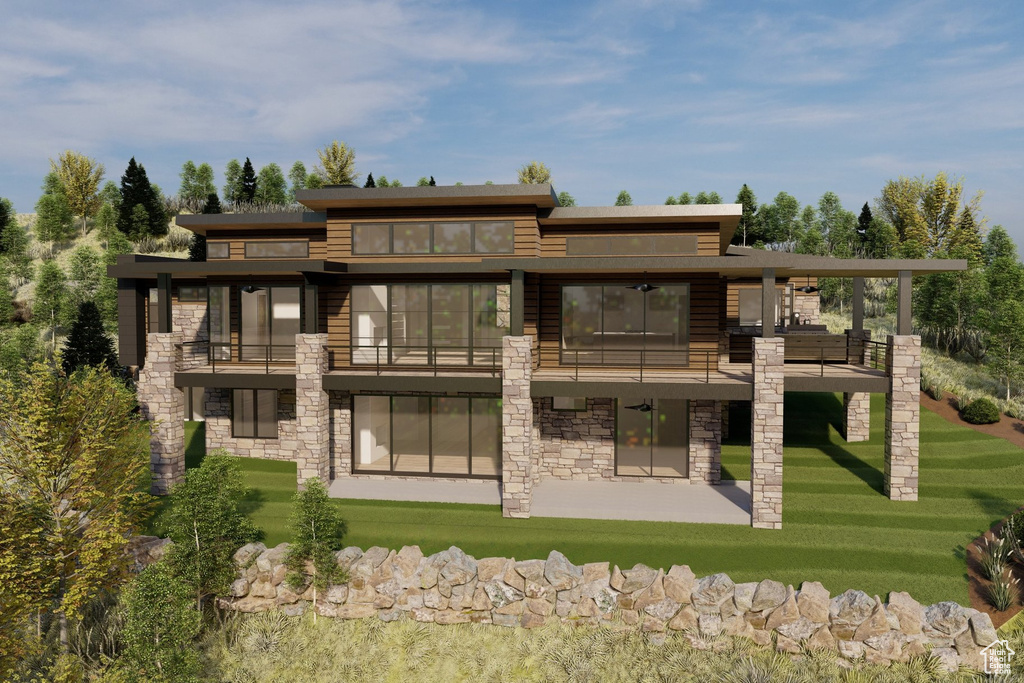 Back of house featuring a balcony, a yard, stone siding, and a patio area