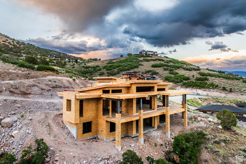 Back of property at dusk featuring a mountain view