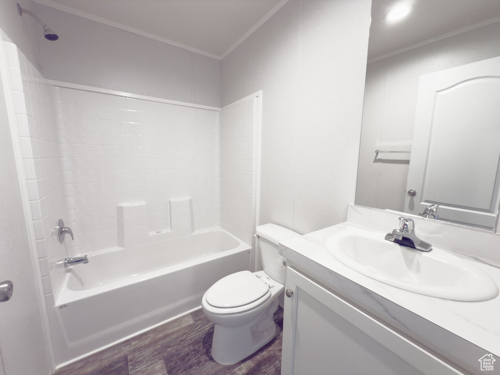 Bathroom featuring wood finished floors, vanity,  shower combination, and crown molding