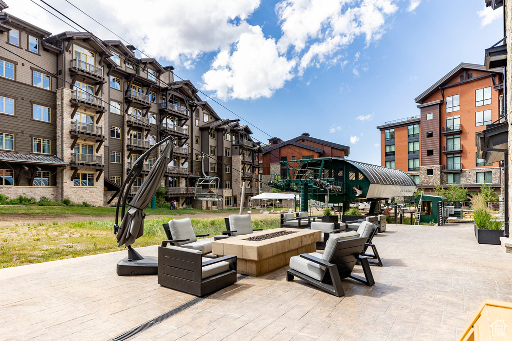 View of property's community featuring a fire pit and a patio