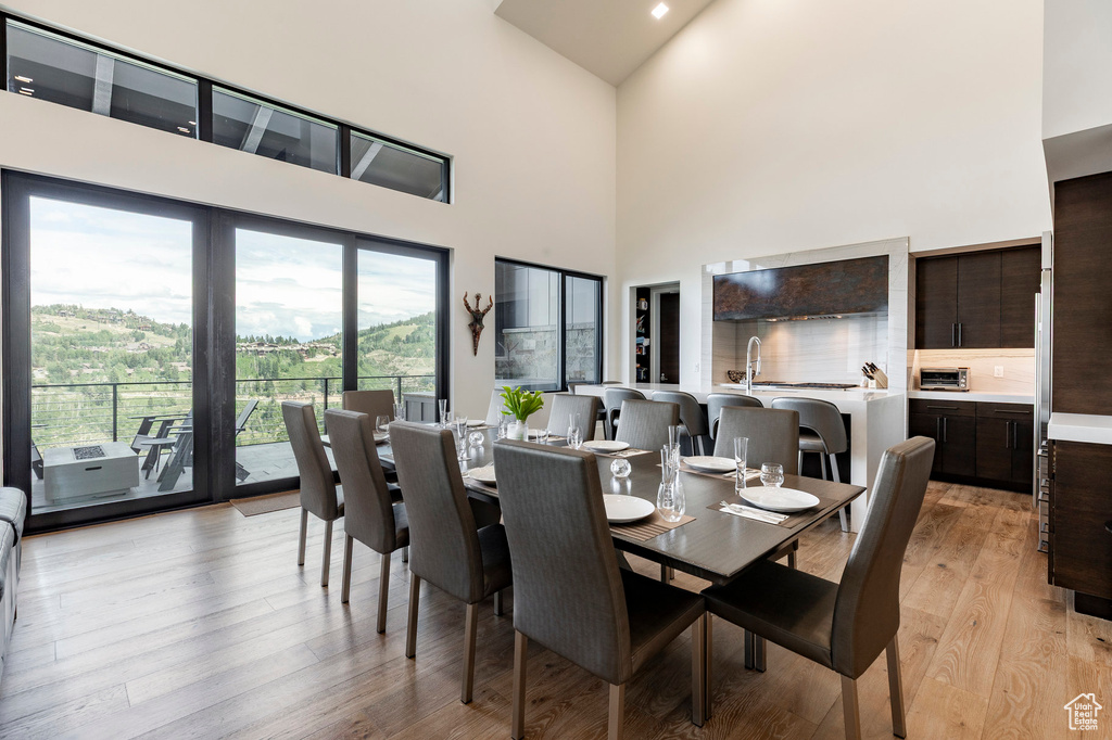 Dining room with high vaulted ceiling and light wood finished floors