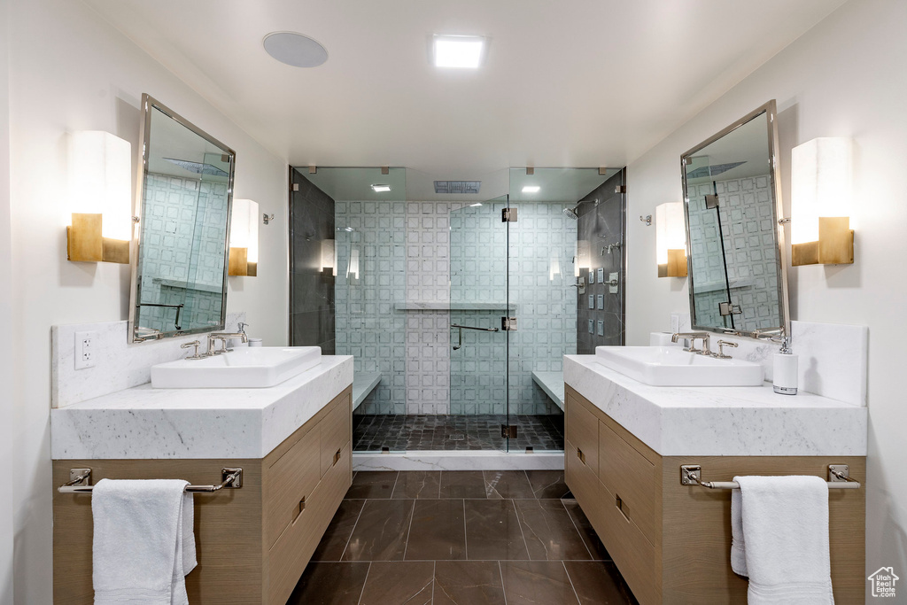 Bathroom featuring a stall shower and two vanities