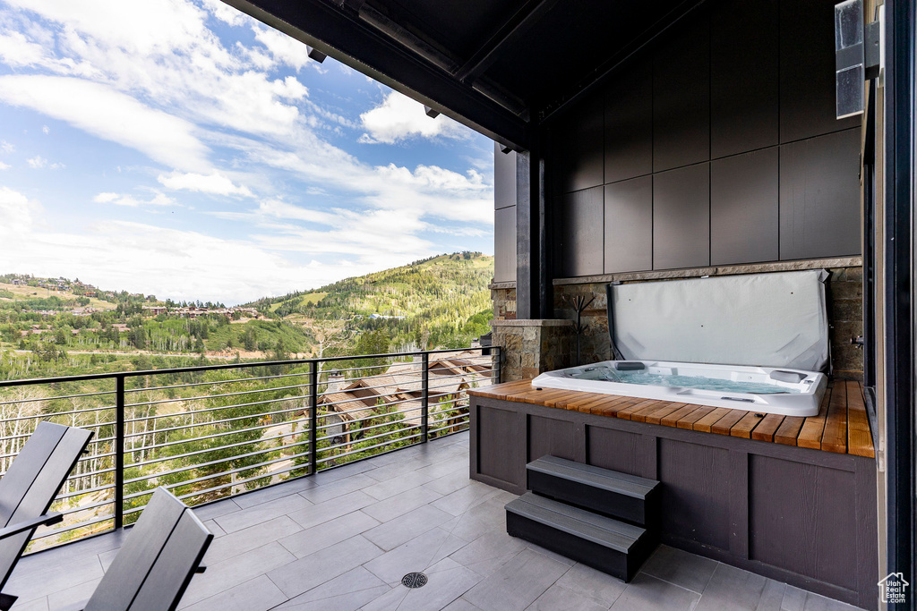 Balcony with a mountain view and a covered hot tub