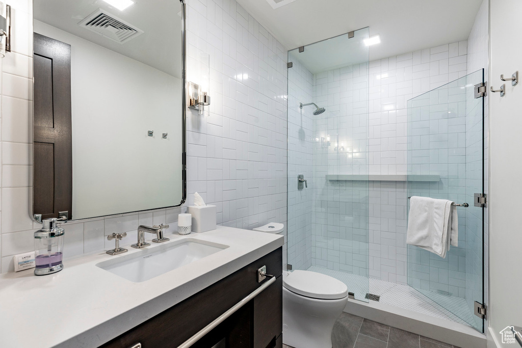 Full bathroom featuring vanity, a shower stall, and tile patterned floors
