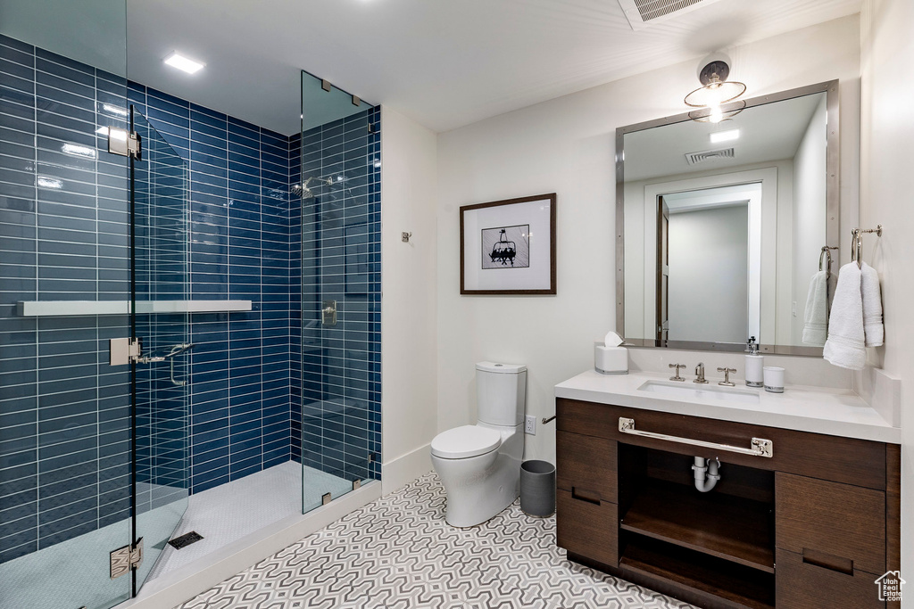 Full bathroom featuring vanity, a stall shower, and tile patterned flooring