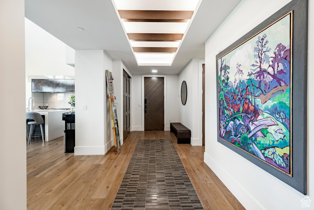 Entrance foyer with baseboards and wood finished floors