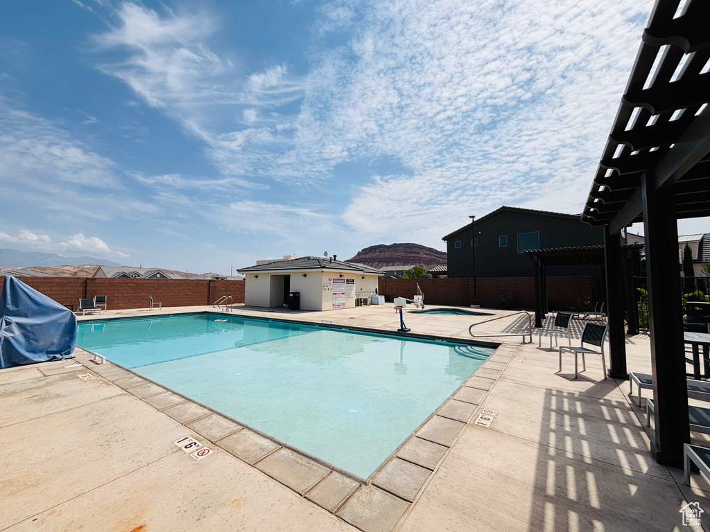 Community pool featuring a pergola, a fenced backyard, a hot tub, grilling area, and a patio
