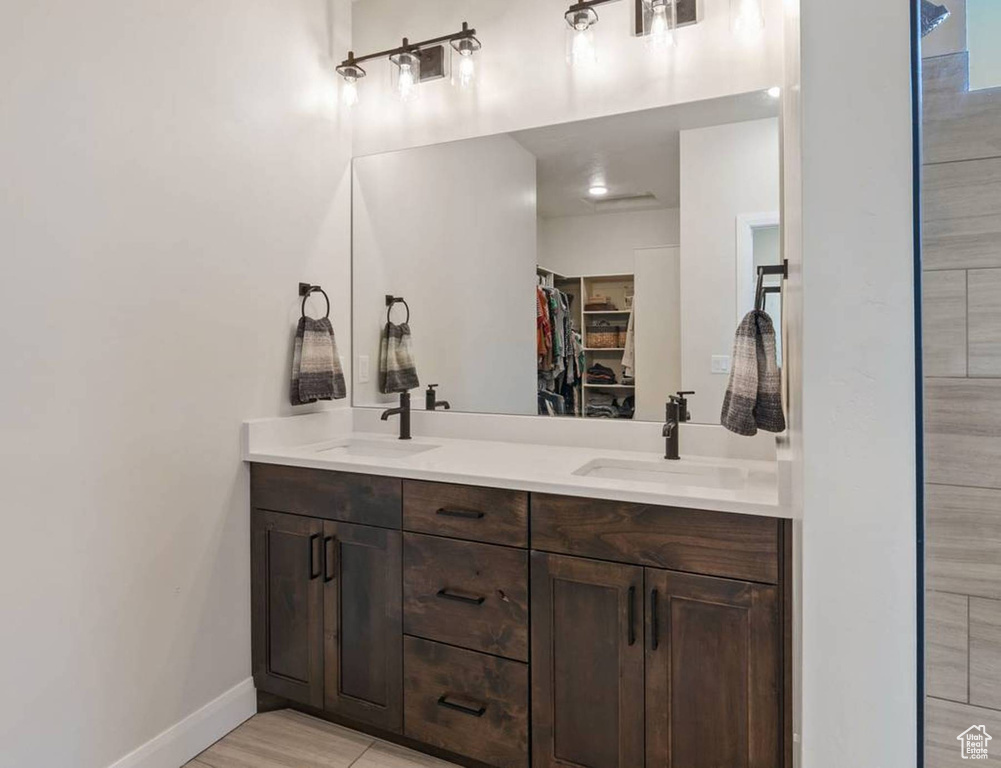 Full bathroom featuring double vanity and a spacious closet