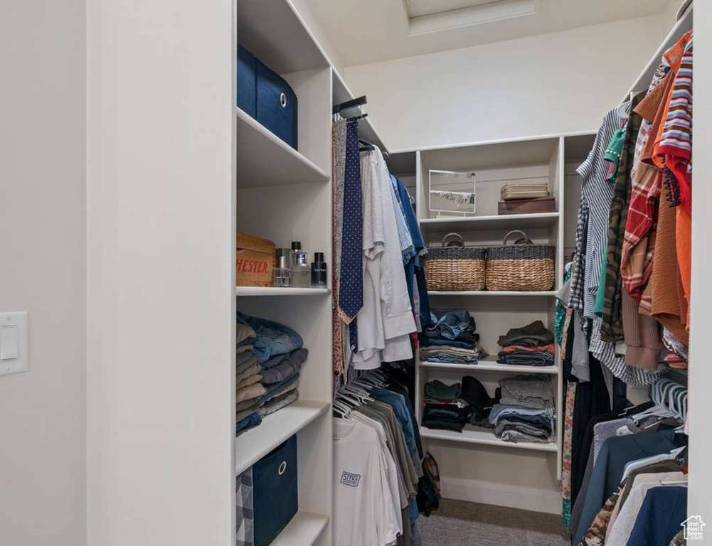 Walk in closet featuring attic access and carpet floors