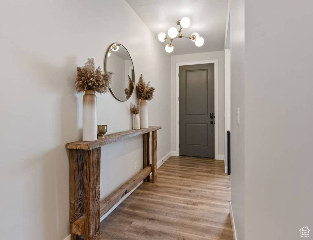 Corridor featuring a chandelier and wood finished floors