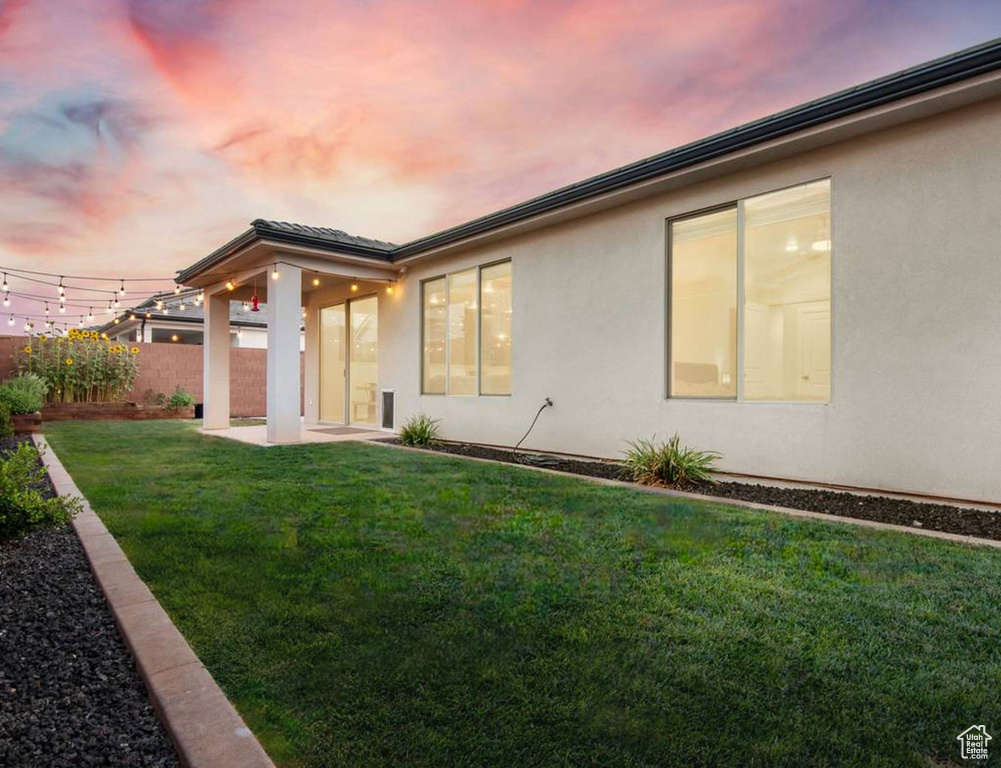 Back of house with stucco siding and a patio area