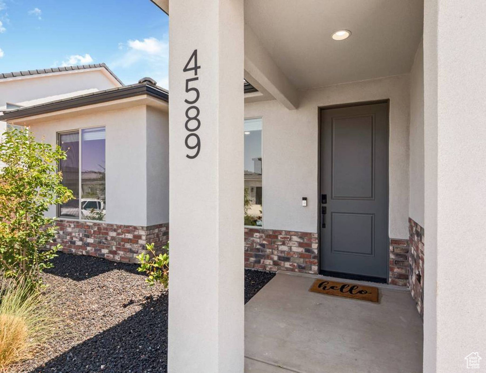 Property entrance with stone siding and stucco siding