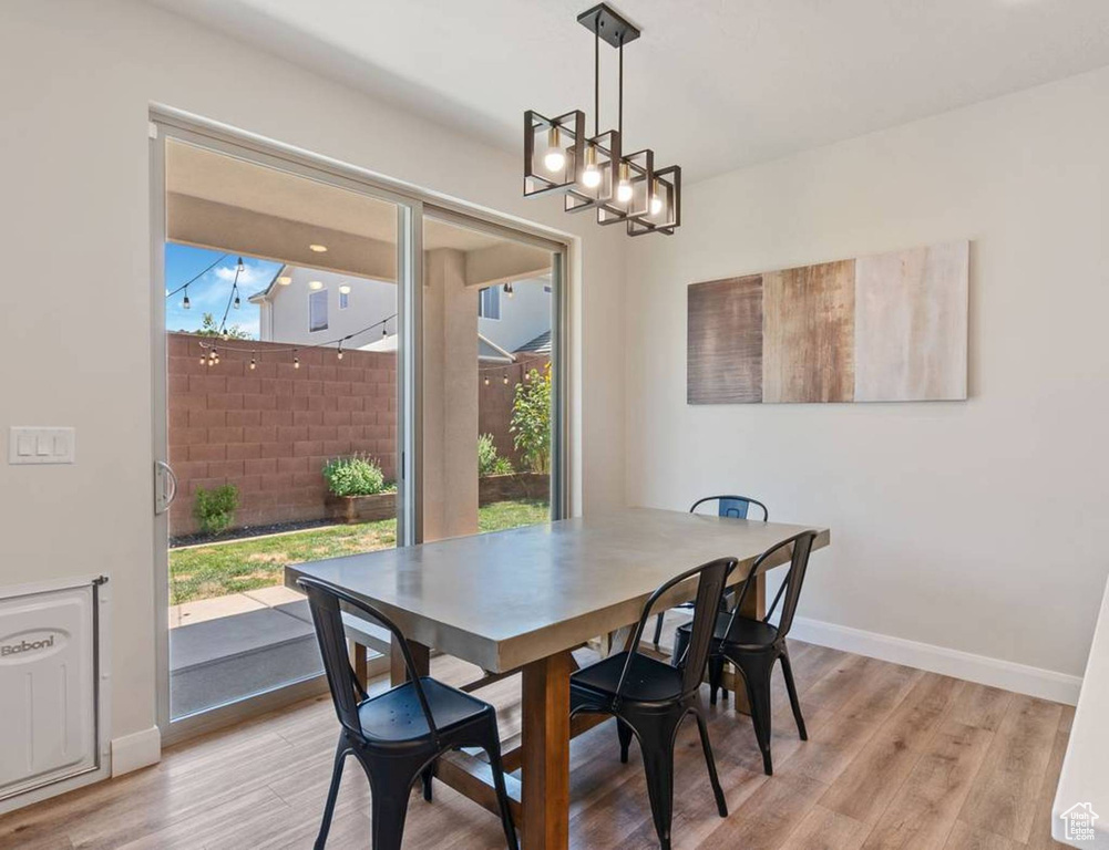 Dining area featuring light wood finished floors and a chandelier