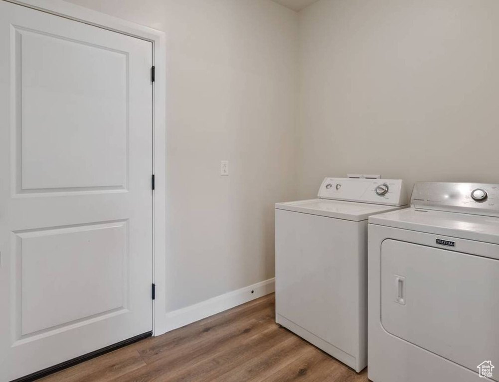 Laundry area featuring independent washer and dryer and light wood finished floors