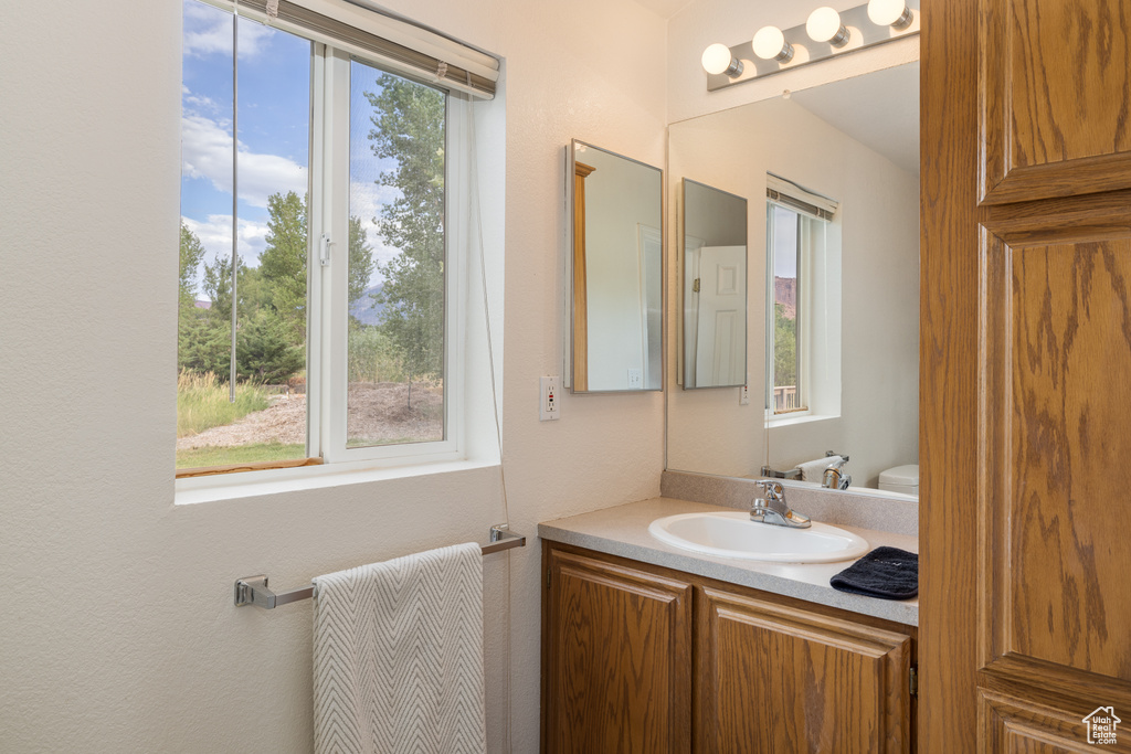 Bathroom with healthy amount of natural light, vanity, and a textured wall