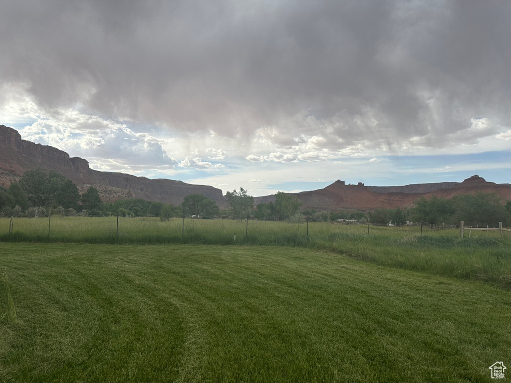 View of green lawn with a mountain view and a view of rural / pastoral area