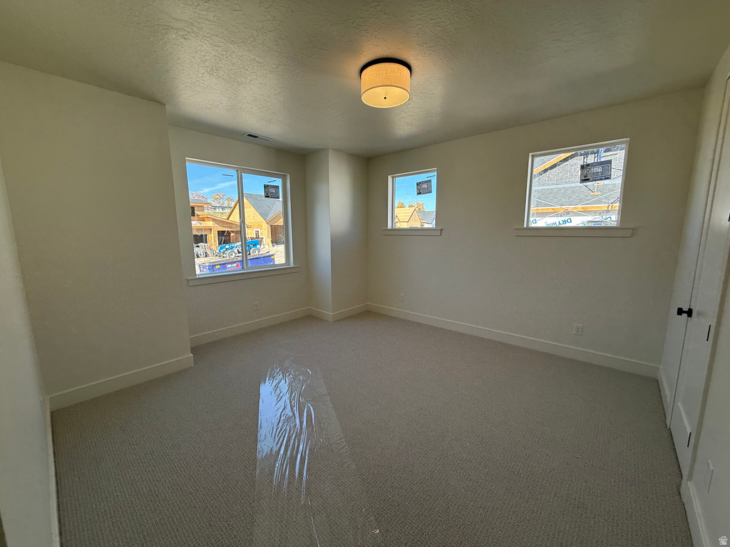 Unfurnished bedroom featuring a textured ceiling and carpet floors