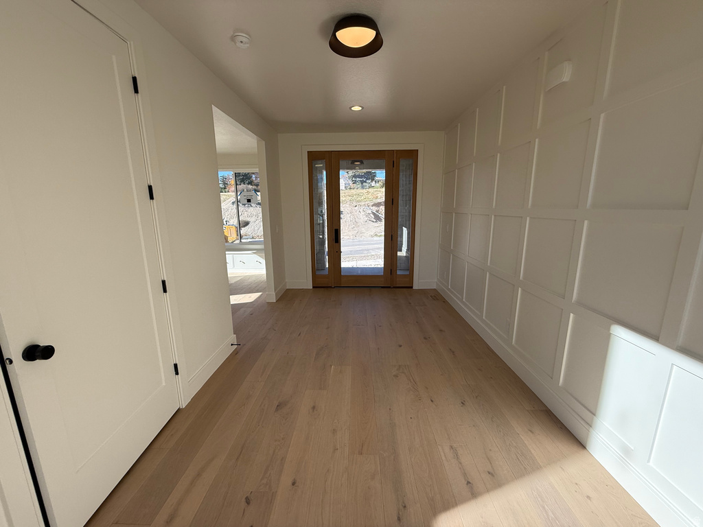 Doorway to outside featuring a decorative wall, wood finished floors, and recessed lighting