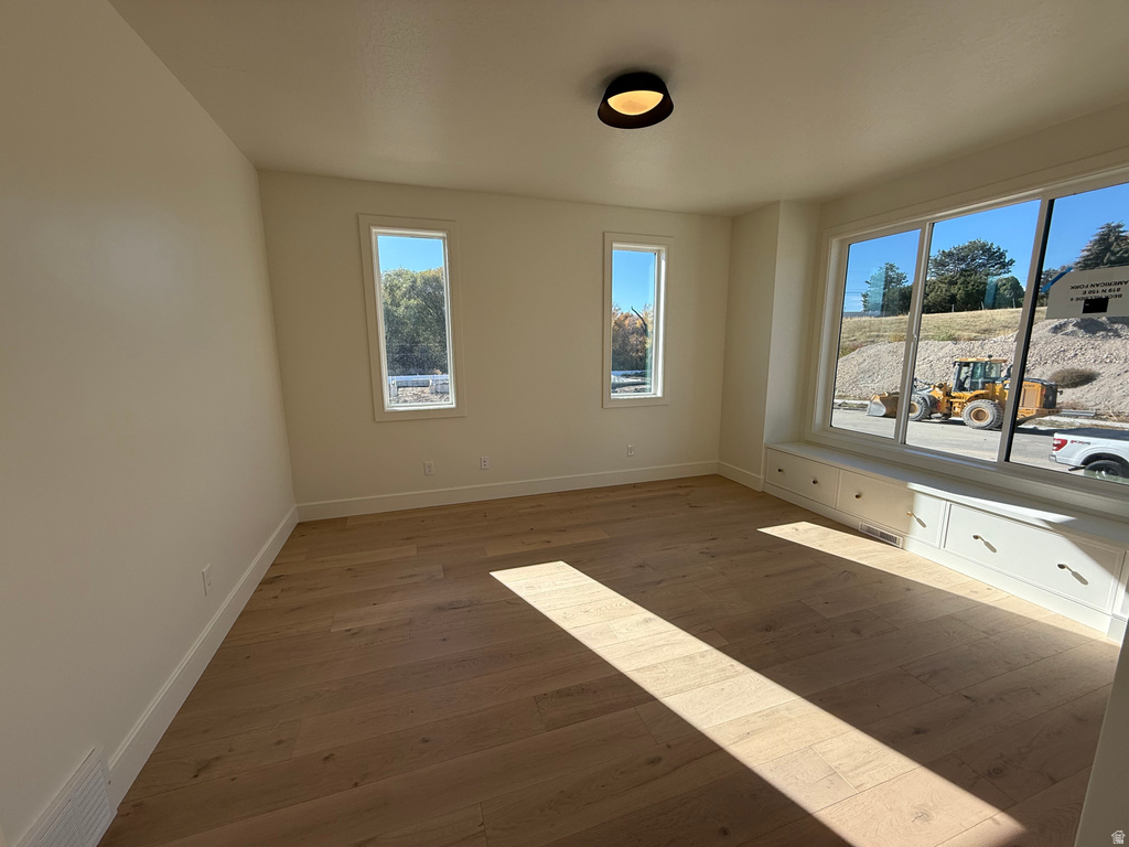 Unfurnished room featuring baseboards and light wood finished floors