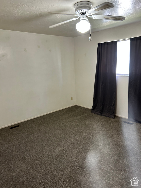 Spare room featuring a ceiling fan and a textured ceiling