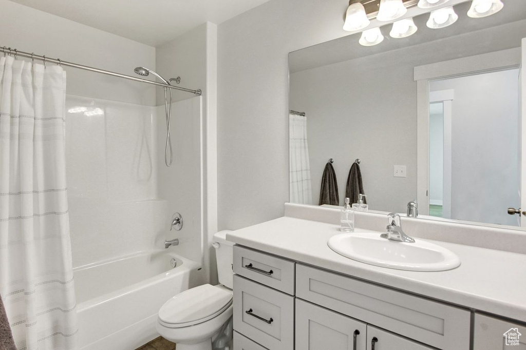 Bathroom featuring vanity and shower / bathtub combination with curtain