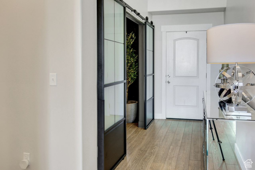 Hall with wood finished floors and a barn door