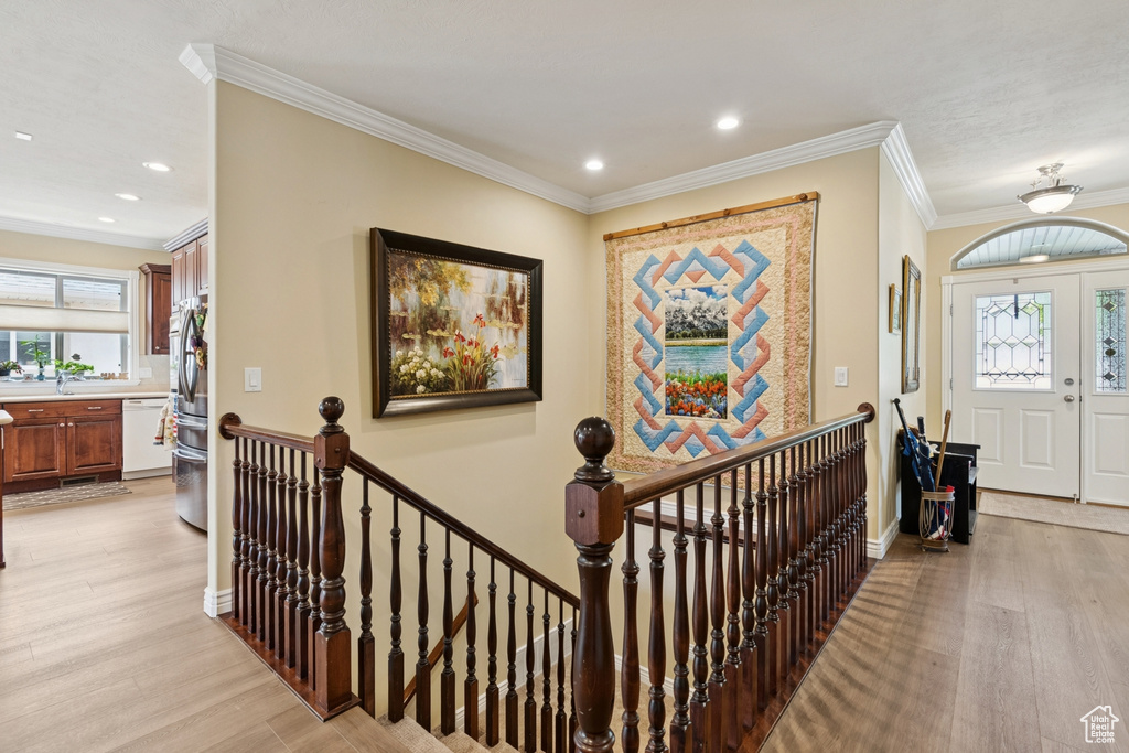 Foyer with light wood-type flooring, recessed lighting, and crown molding