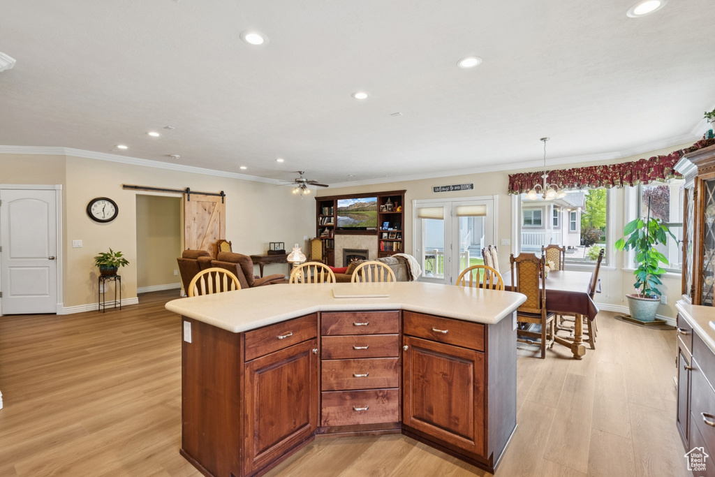 Kitchen with a barn door, light countertops, recessed lighting, a ceiling fan, and crown molding