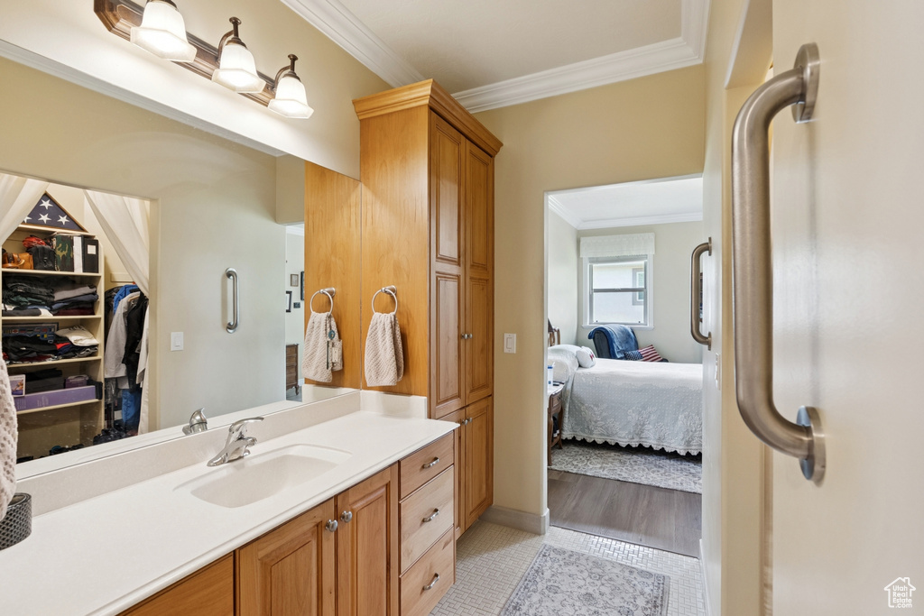 Bathroom featuring ornamental molding, vanity, ensuite bathroom, and tile patterned flooring