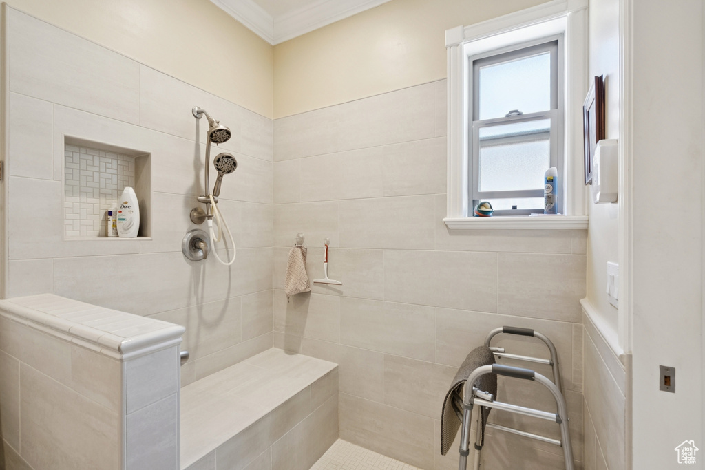 Bathroom featuring tiled shower and ornamental molding