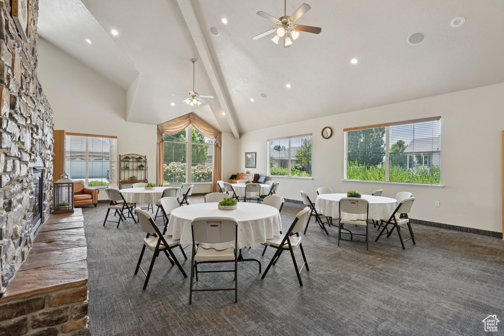 Dining area with a ceiling fan, high vaulted ceiling, recessed lighting, beam ceiling, and a fireplace