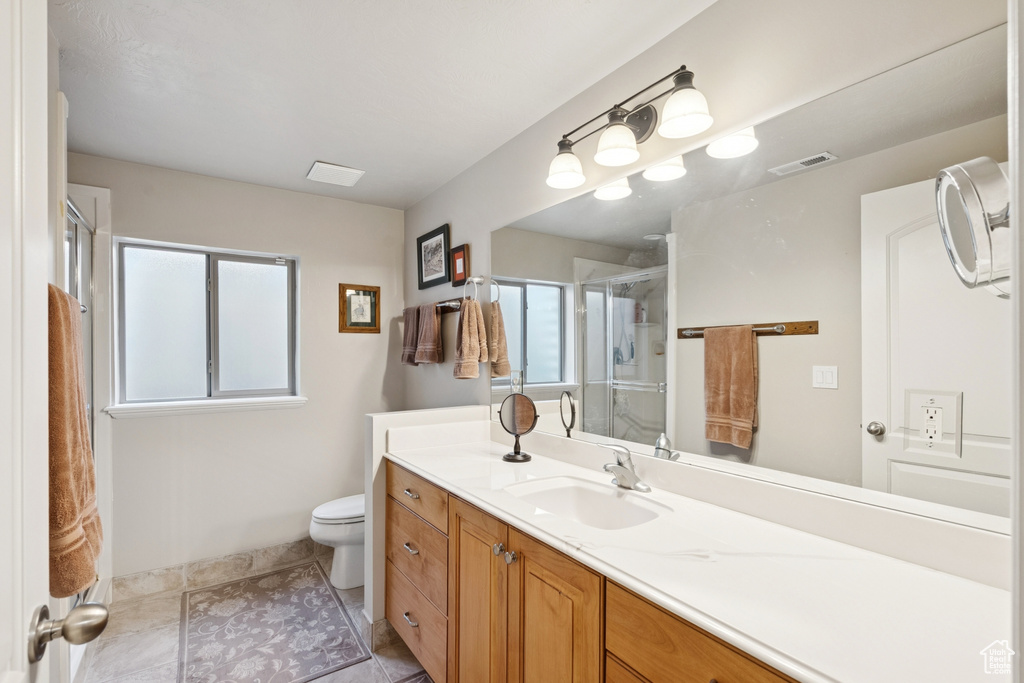 Full bath with vanity, a stall shower, and tile patterned floors