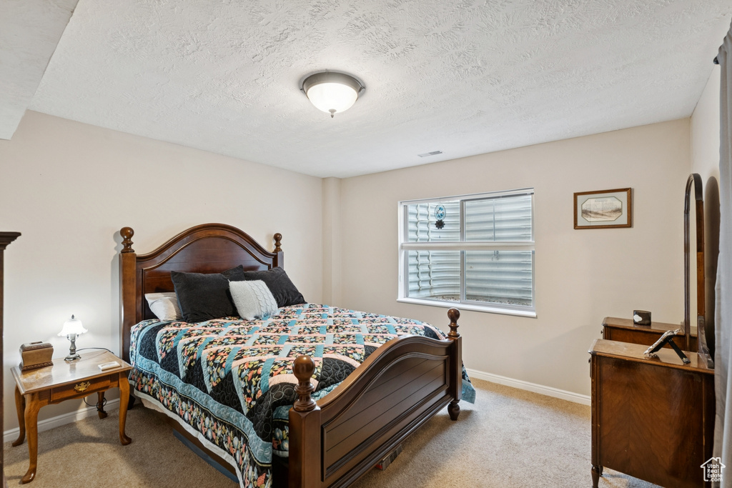 Bedroom with carpet flooring and a textured ceiling