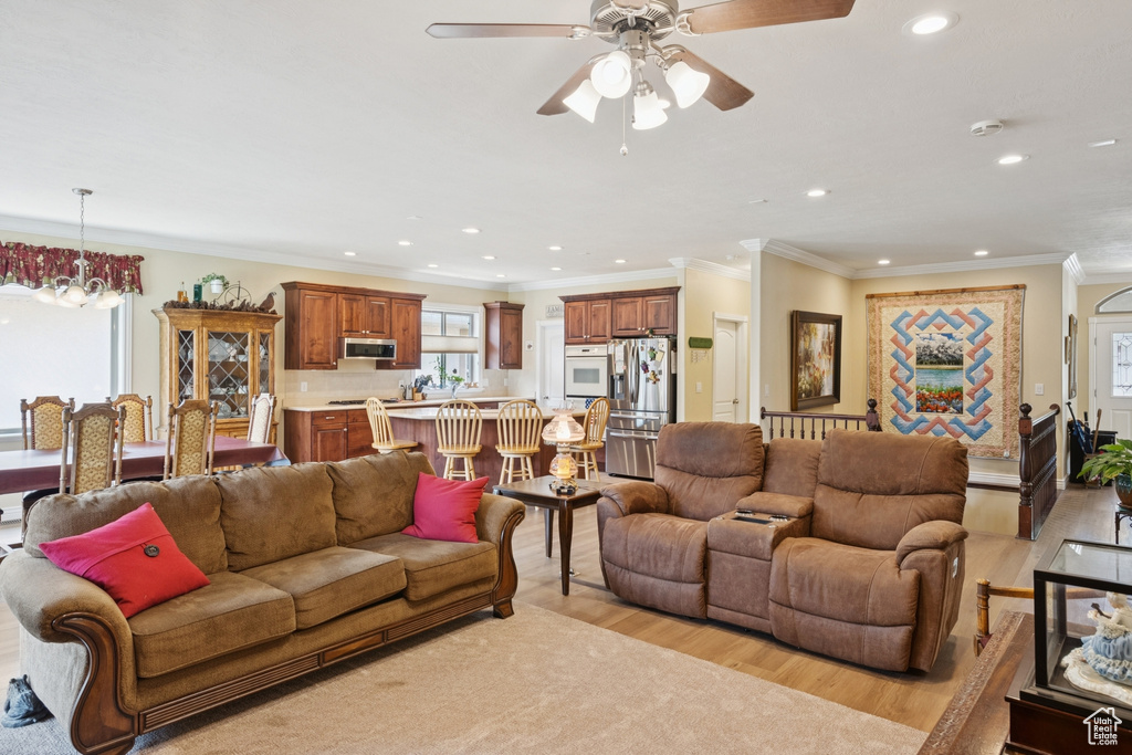Living area featuring light wood-style floors, recessed lighting, ceiling fan, and ornamental molding