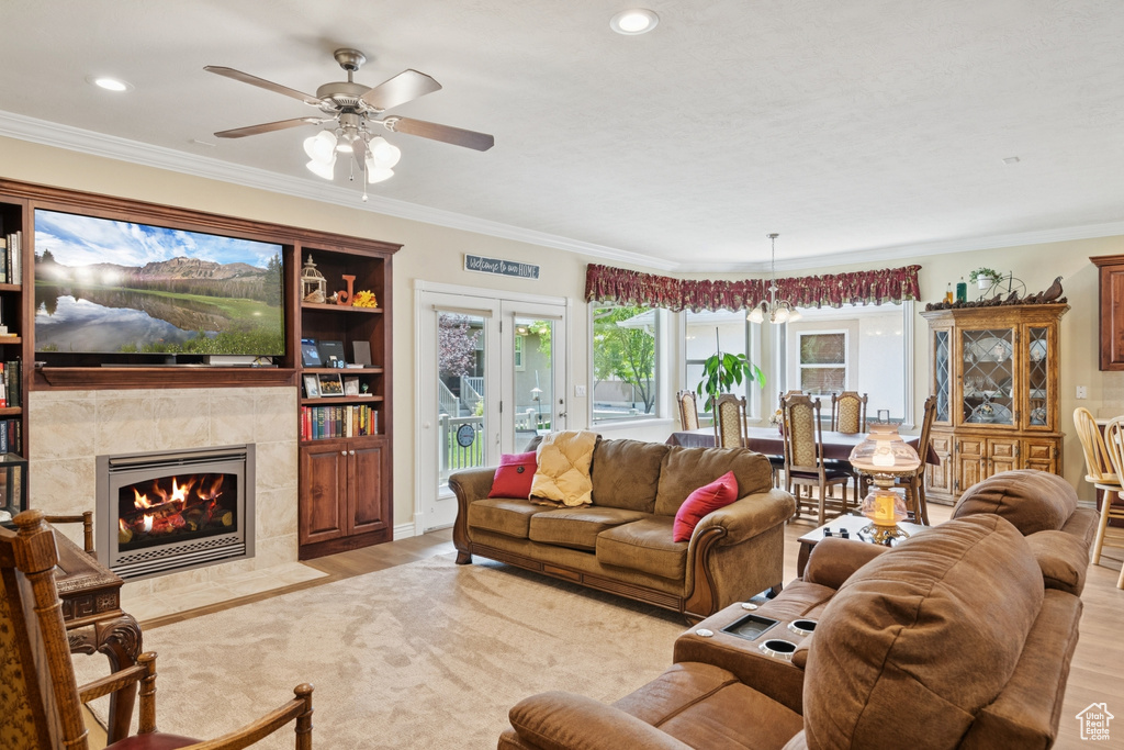 Living area with a ceiling fan, plenty of natural light, light wood-style floors, ornamental molding, and recessed lighting