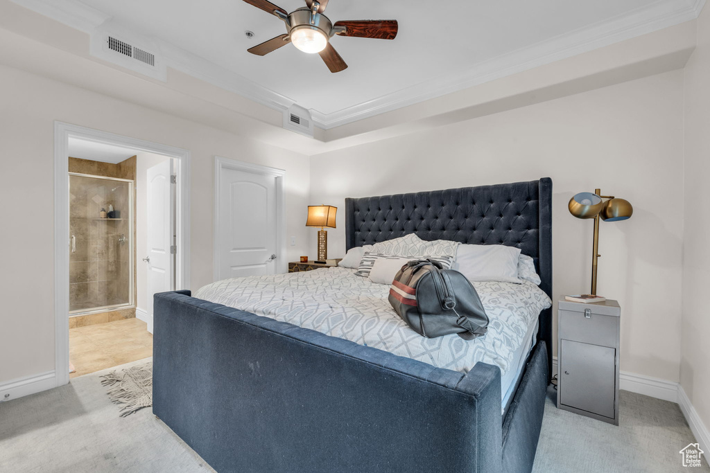 Bedroom featuring light carpet, crown molding, ensuite bathroom, and a ceiling fan